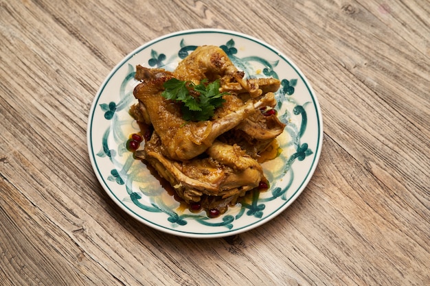 Fried chicken legs with pomegranate and parsley on wood table background with copy space, top view