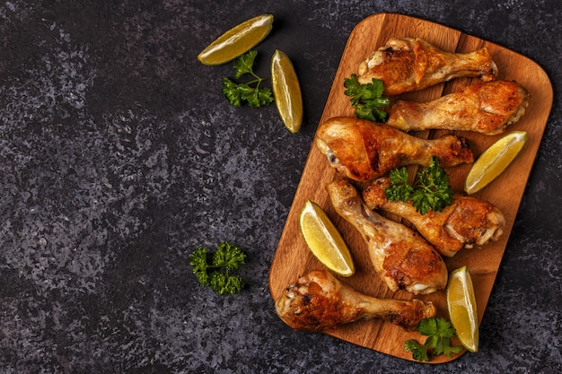 Fried chicken legs on wooden board