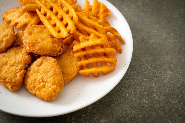 fried chicken nuggets with fried potatoes on plate