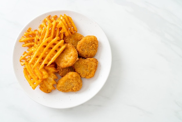 fried chicken nuggets with fried potatoes on plate