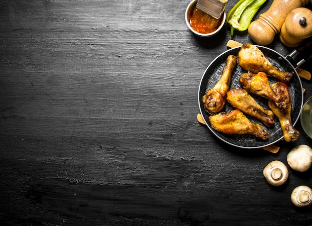 Fried chicken in a pan with mushrooms , garlic and tomato sauce.