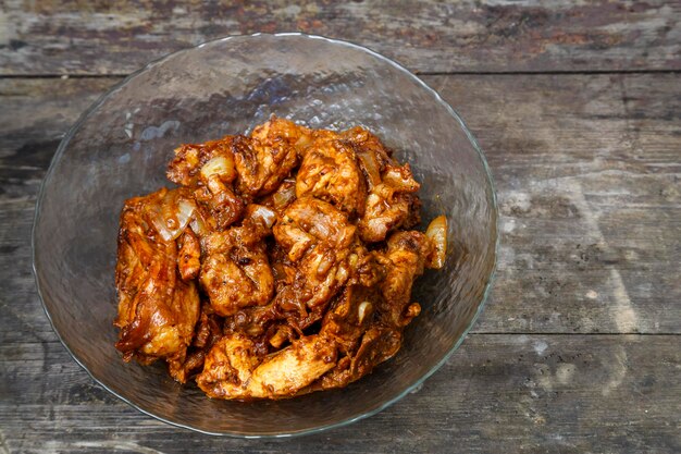 Fried chicken in sauce in a glass plate on the table