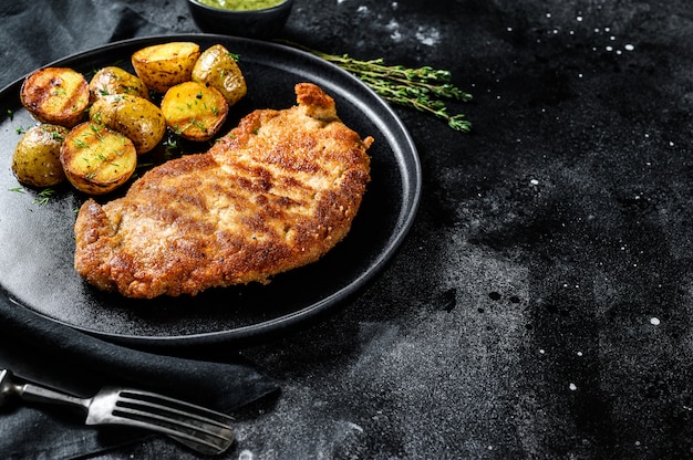 Fried chicken-schnitzel met gebakken aardappels.