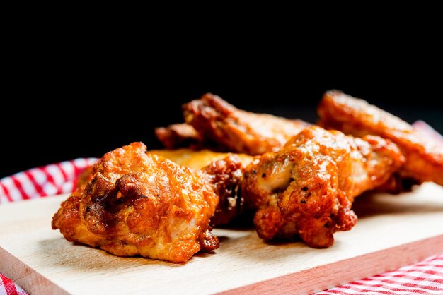 Photo fried chicken wings on cutting board against black background