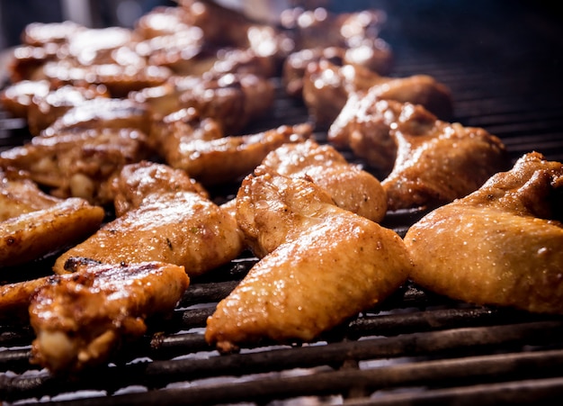 Fried chicken wings at grill barbecue. Restaurant.