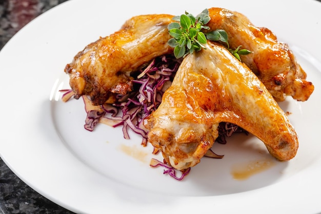 Fried chicken wings lie on a white plate