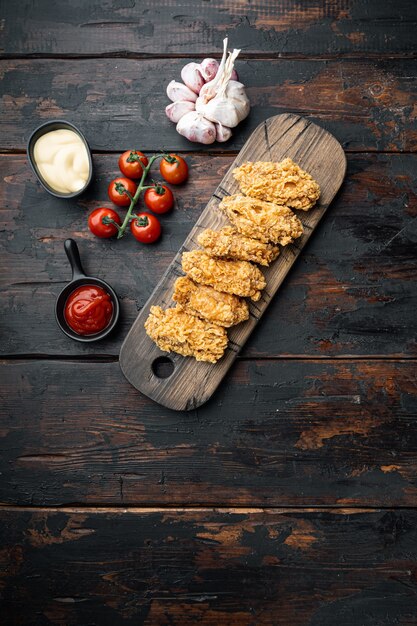 Parti di ali di pollo fritte sul vecchio tavolo di legno scuro, vista dall'alto