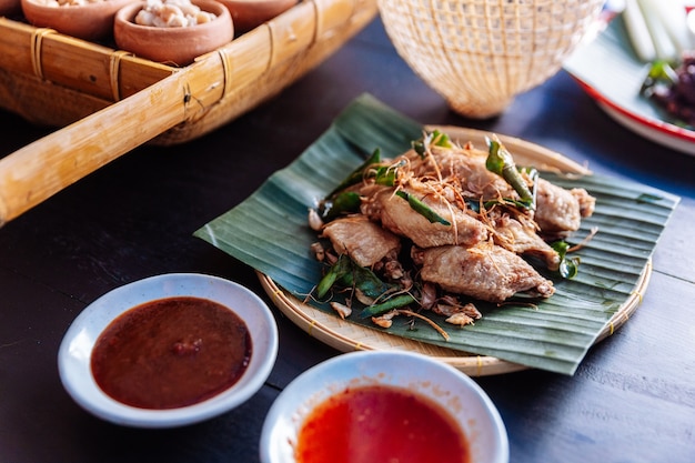 Photo fried chicken wings in thai northeastern style with garlic and kaffir lime leaves.