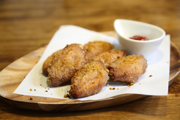 Fried chicken wings on wood background with restaurant light