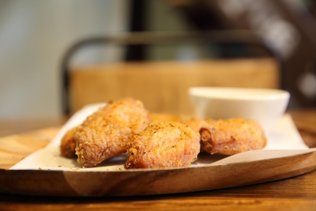 Fried chicken wings on wood background with restaurant light