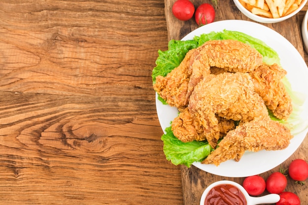 Fried chicken wings on wooden table.