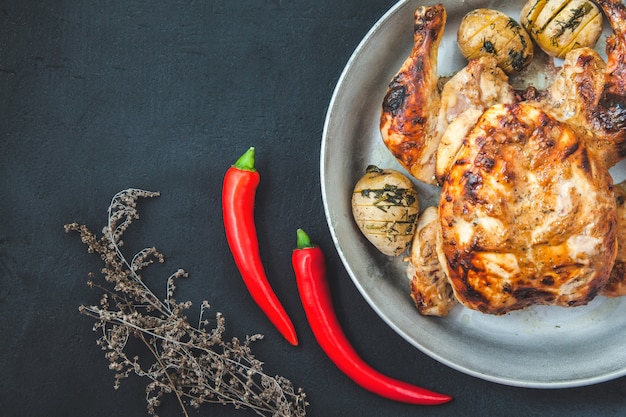 Fried chicken with baked potatoes in a frying pan