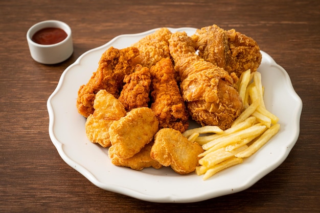 fried chicken with french fries and nuggets on plate - unhealthy food