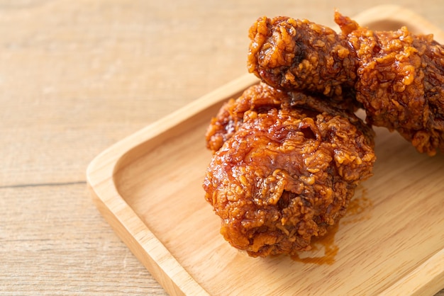 Fried chicken with spicy Korean sauce on wood plate