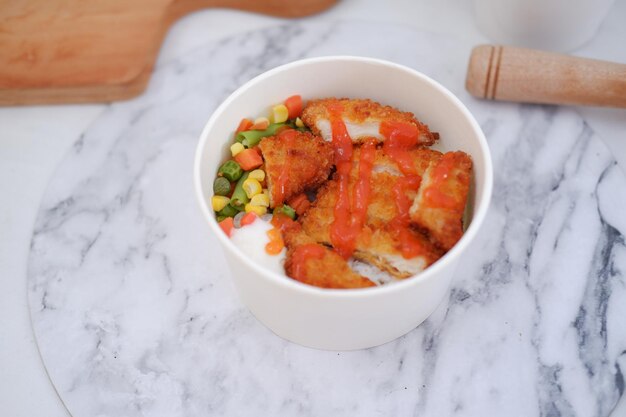 Fried chicken with sweet pepper and tomato in white bowl table