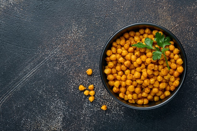 fried chickpeas with turmeric with parsley and lime in black plate