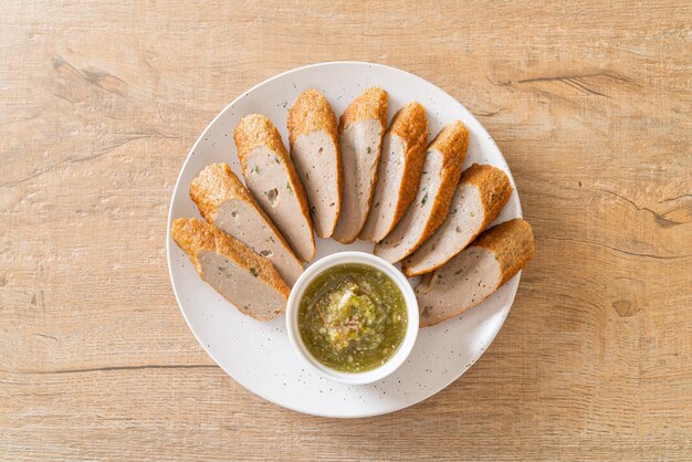 fried Chinese fish cake or fish ball line sliced with spicy seafood dipping sauce