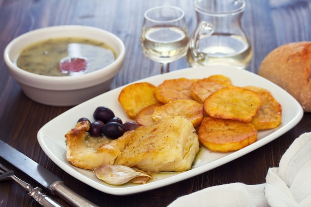 Fried cod fish with potato on white dish