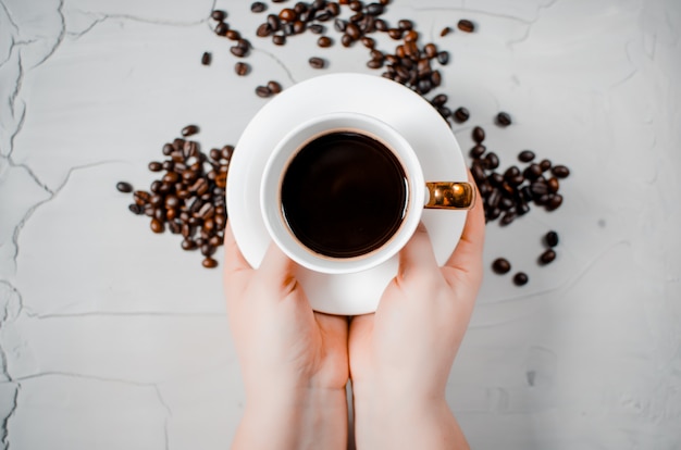 Fried coffee beans and in the hands of the girl a cup