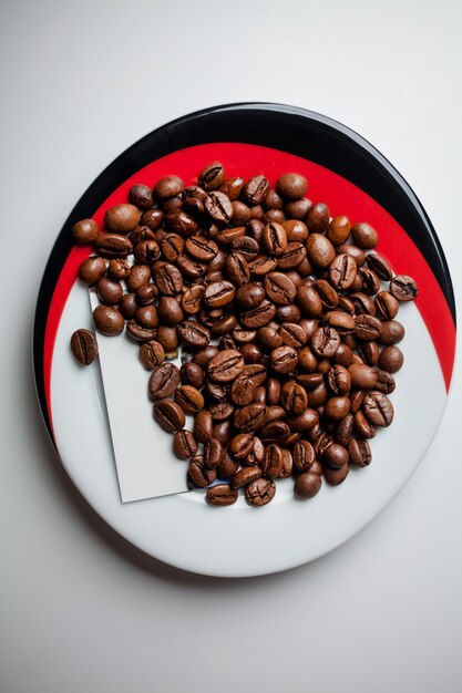 fried coffee beans in a saucer on a white background Coffee beans as background isolated on white