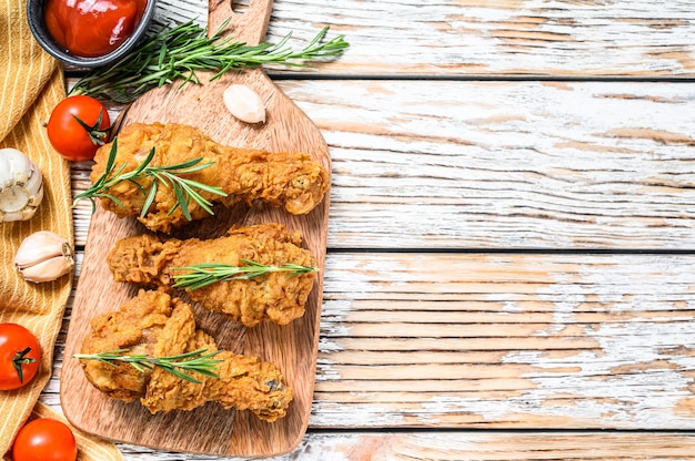 Fried crispy chicken legs on a cutting board