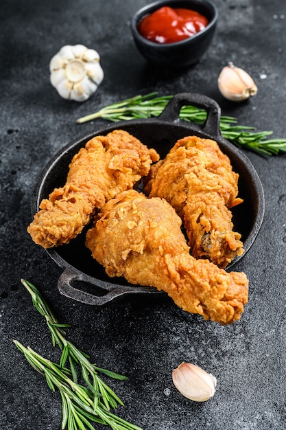 Fried crispy chicken legs in a pan