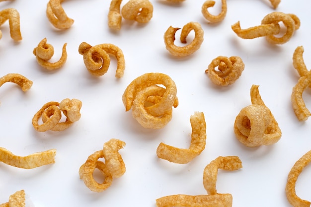 Fried crispy pork rinds on white background.