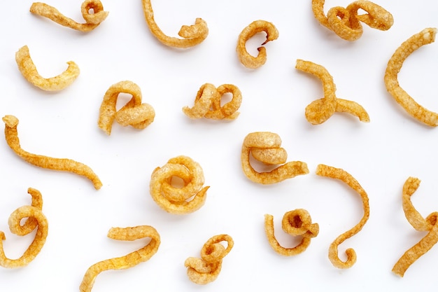 Fried crispy pork rinds on white background.