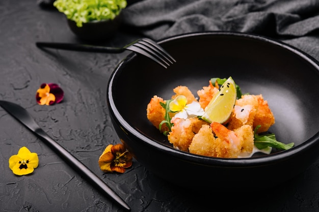 Fried crispy shrimp on black plate