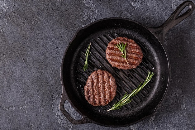 Fried cutlet for burger with spices on grill pan, top view, copy space.