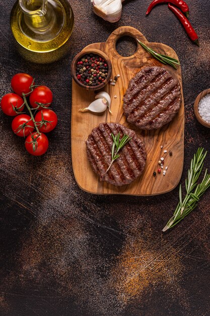 Cotoletta fritta per hamburger su una tavola di legno, vista dall'alto, copia spazio.