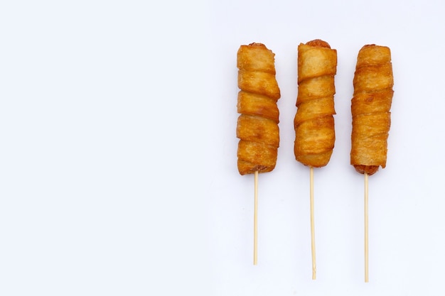 Fried dough snacks wrapped sausage on white background.