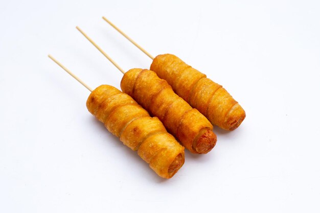 Fried dough snacks wrapped sausage on white background.