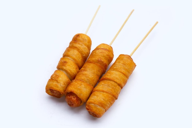 Fried dough snacks wrapped sausage on white background.