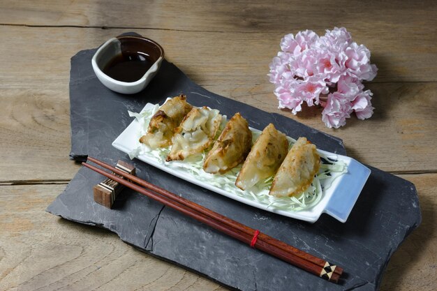 fried dumplings or gyoza on wood background