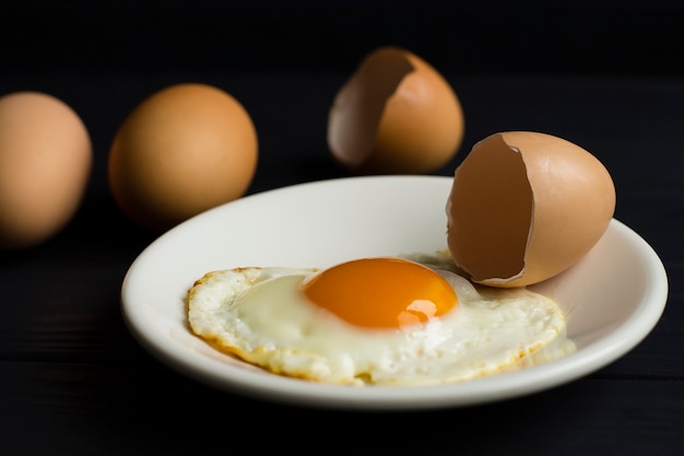 fried egg, eggshell, on a white plate
