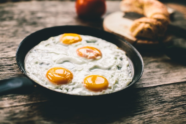 Fried egg in a frying pan on a wooden table