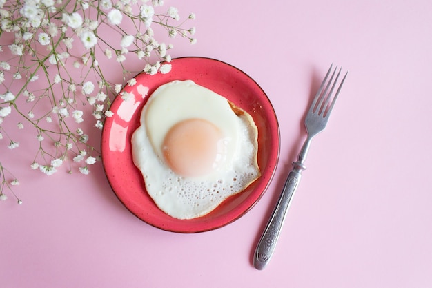 Жареные яйца на розовом фоне
