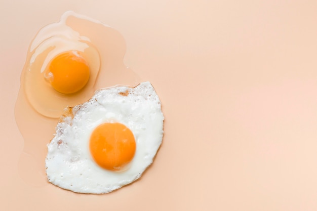 Fried egg and raw egg yolk with copy-space