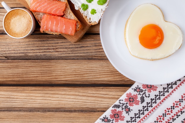 fried egg in the shape of a heart on a white plate 