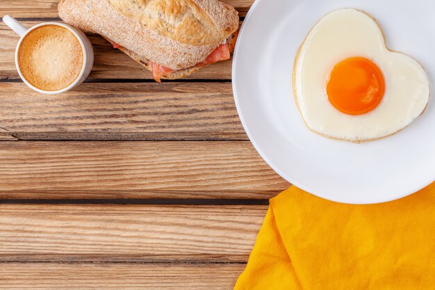 Photo fried egg in the shape of a heart on a white plate