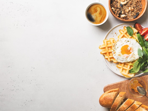 Photo fried egg spinach waffles and cup of coffee espresso bread baguette muesli on white background