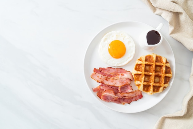 Uovo fritto con bacon e waffle per colazione