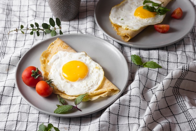 Photo fried egg with crepe and tomatoes