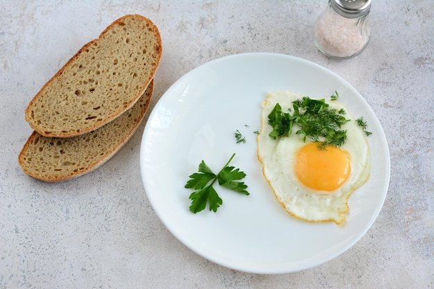 fried egg with parsley and slices of bread, close-up