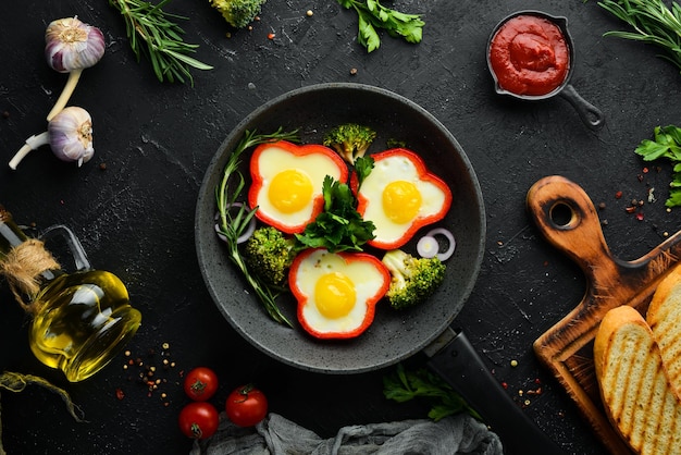 Fried egg with sweet pepper on a black plate Top view Free copy space