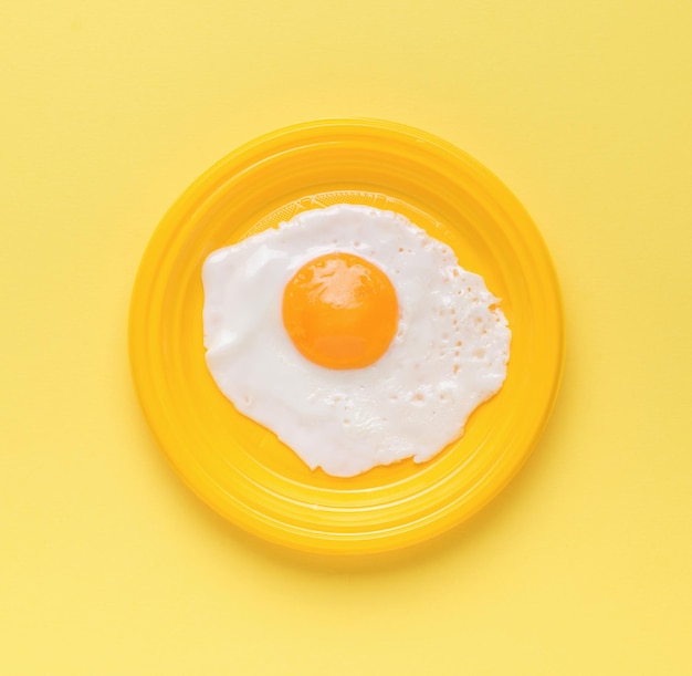 노란색 배경에 노란색 접시에 튀긴 계란 최소 개념 인기 있는 아침 식사