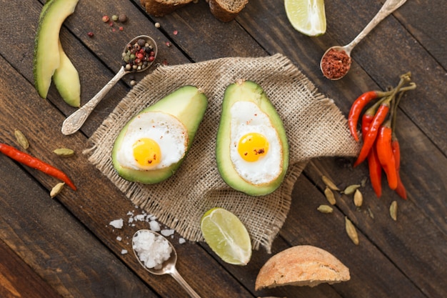 Fried eggs in avocado with red pepper and various spices.