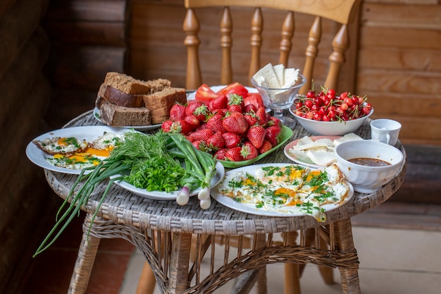 Fried eggs bread greens vegetables berries and cheese serving for breakfast