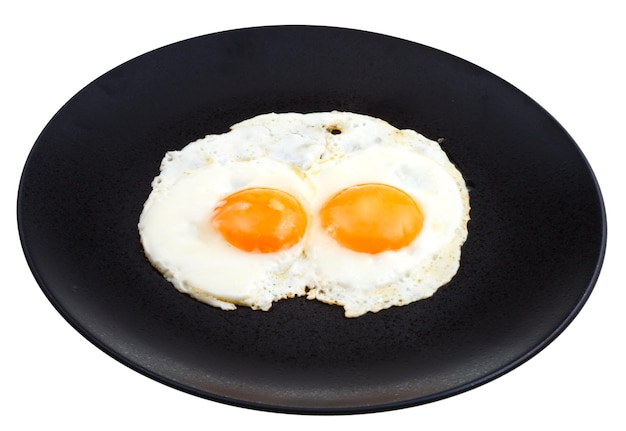 Photo fried eggs on ceramic black plate